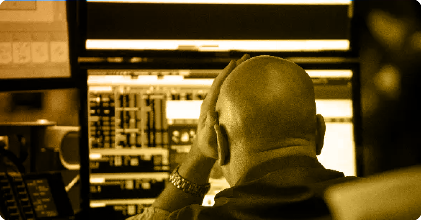 A man at his desk with two monitors displaying "the stock market is a gamble," contemplating take-profit and stop-loss strategies.